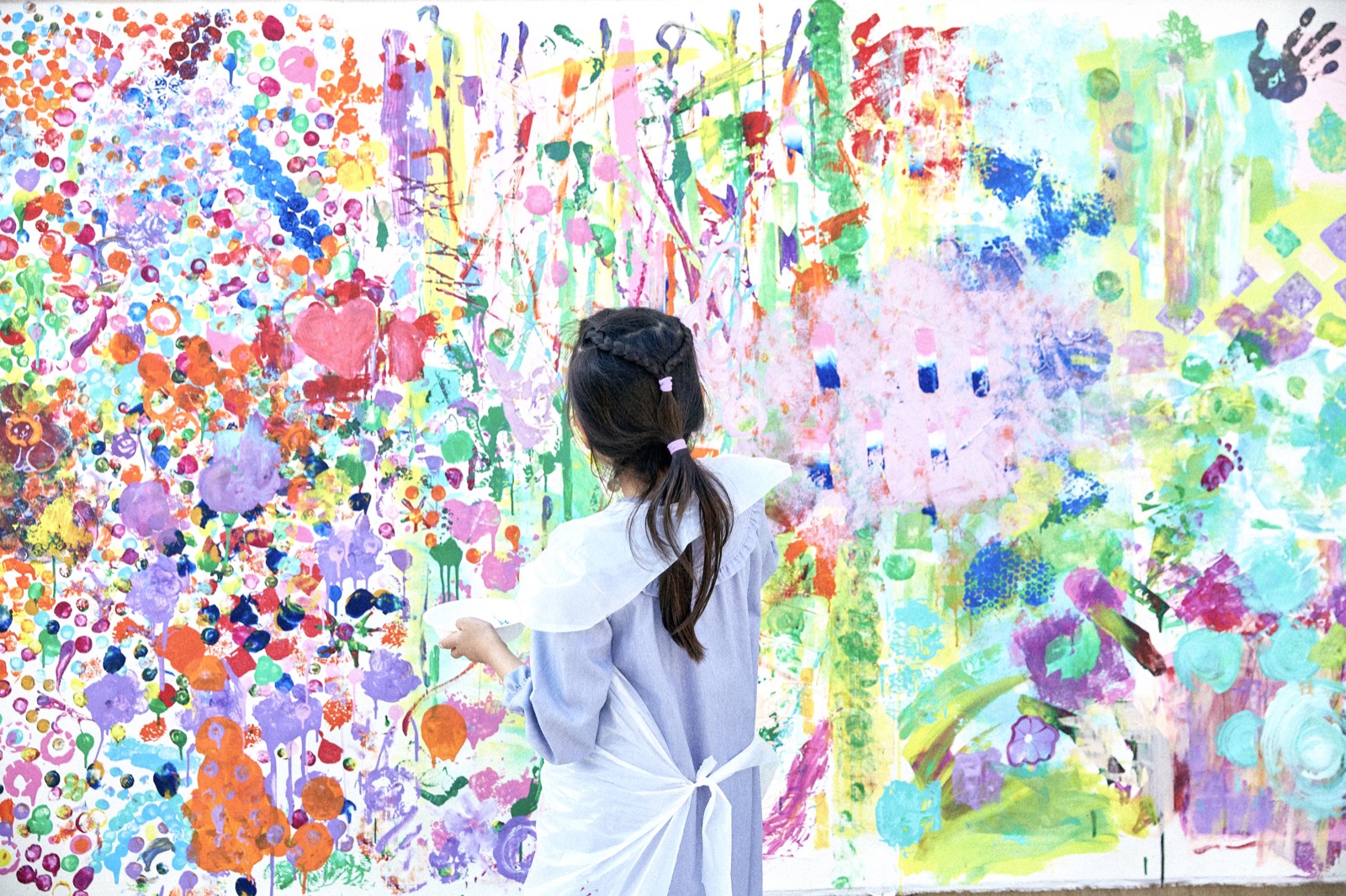 大きな作品の前で制作する子ども